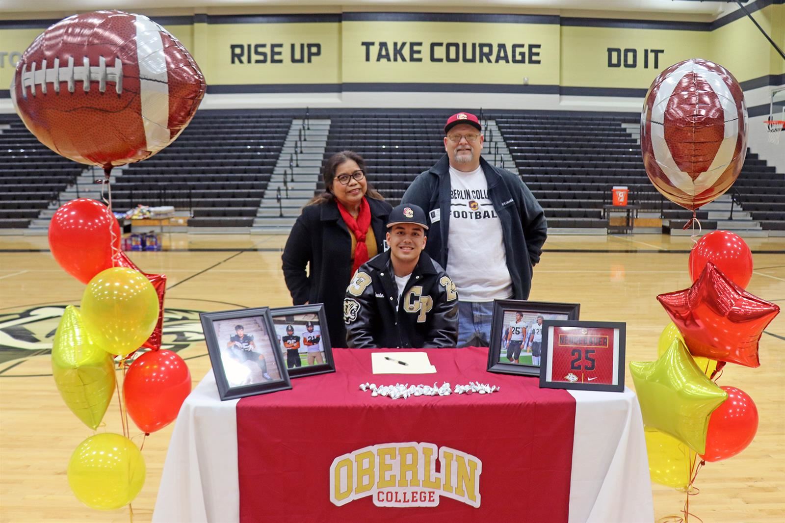 Cypress Park High School senior Devin Neugebauer, seated, signed his letter of intent to play football at Oberlin College.